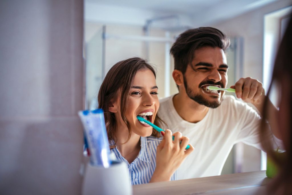 Frau und Mann putzen Zähne