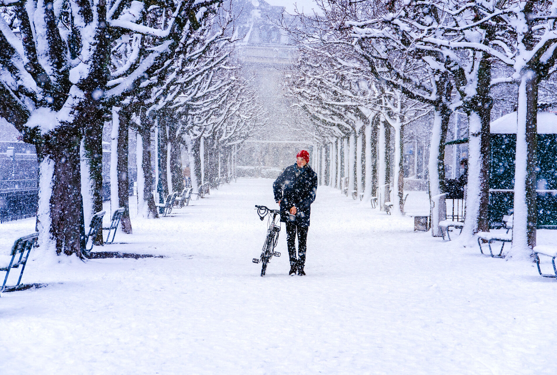 Mann schiebt Fahrrad im Schnee